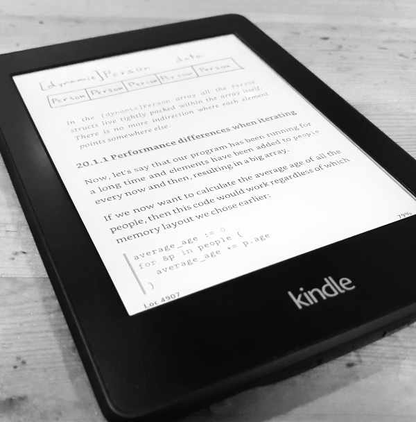 Shows an Amazon Kindle with the book open. There's an illustration visible, some headings and a bit of code.